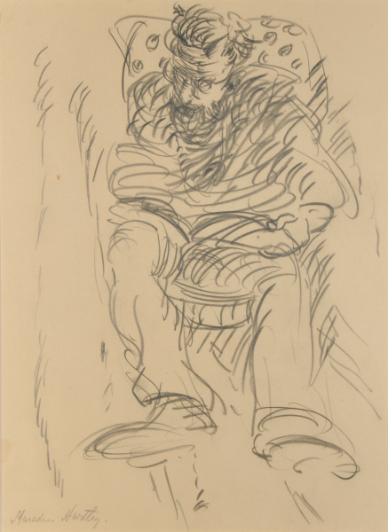 MAN SEATED IN A PATTERNED CHAIR READING