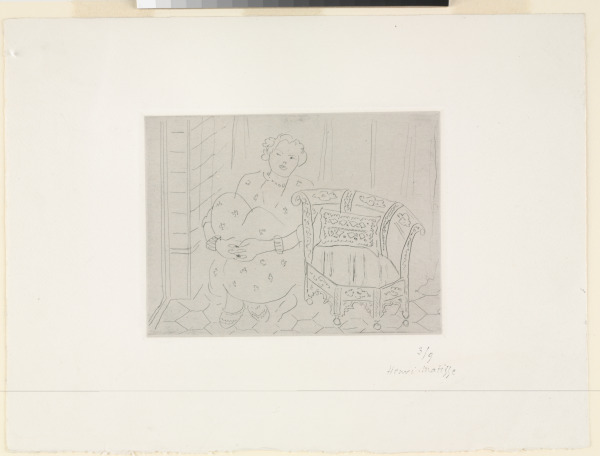 FIGURE CROUCHING NEAR AN ORIENTAL ARMCHAIR