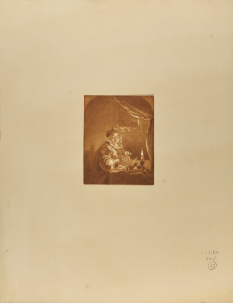 Une femme travaillant a la lueur d'une chandelle