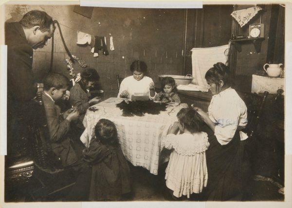 FATHER HANGING AROUND THE HOME WHILE FAMILY WORKS ON FEATHERS