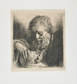 Old man looking at skull